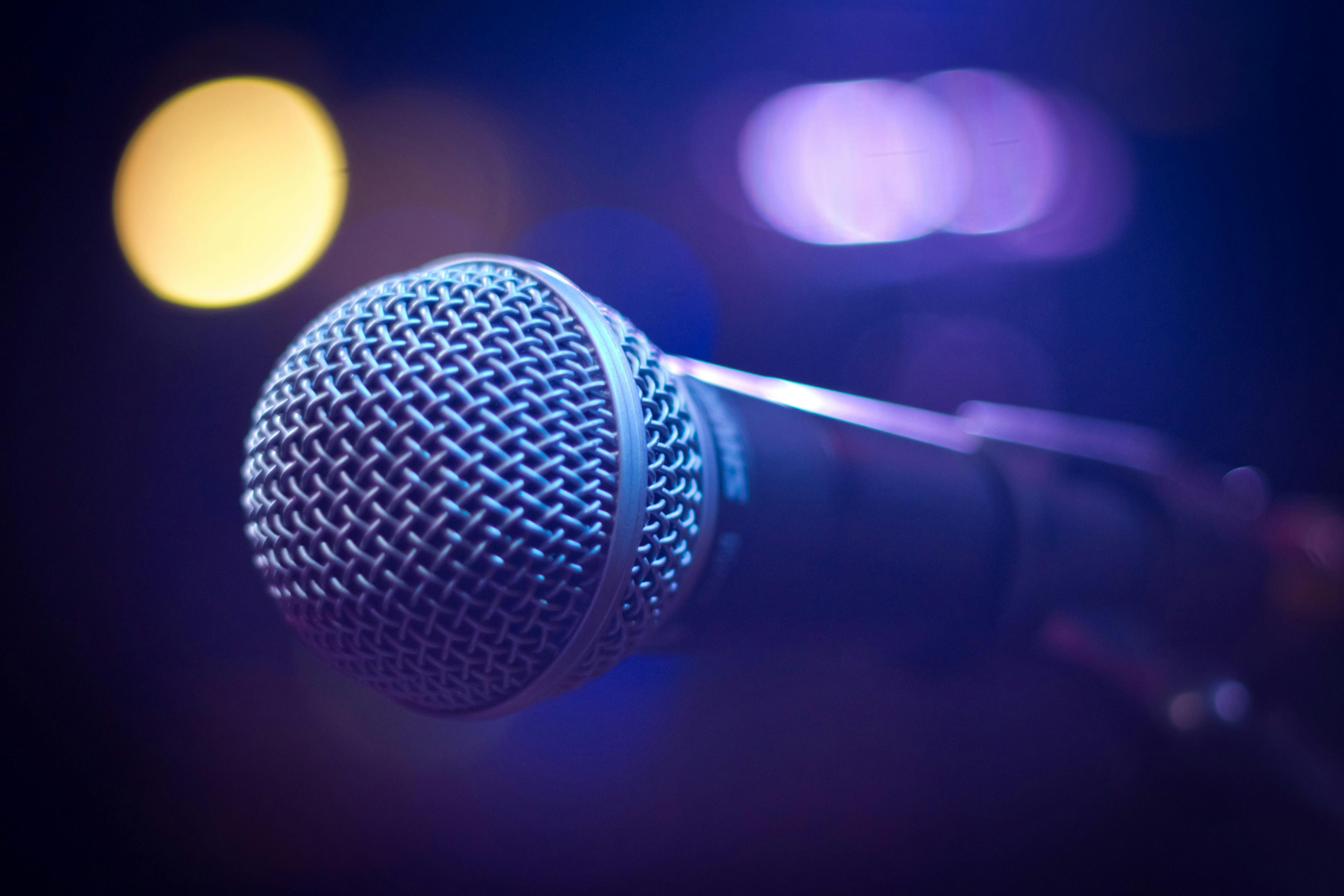 An artistic close-up of a microphone with blurred bokeh lighting, perfect for music themes.